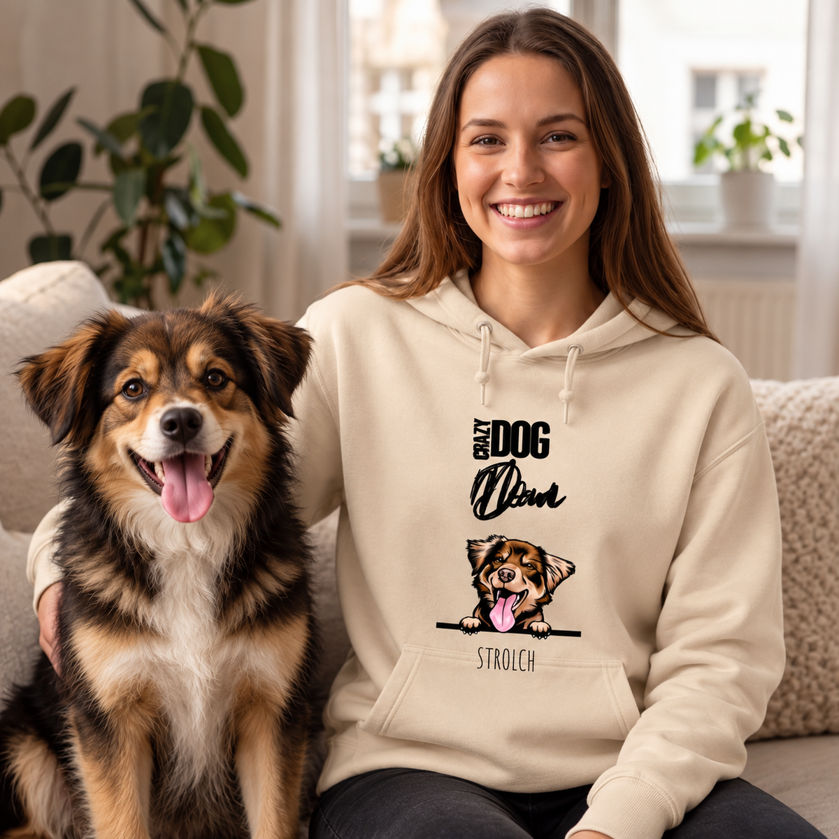 Beige hoodie met opdruk voor huisdierouders, vrouw zit met hond op de bank.
