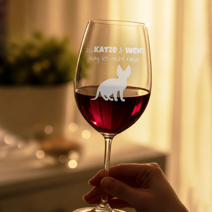 Gepersonaliseerd wijnglas met gegraveerd opschrift en kattenmotief, gevuld met rode wijn.