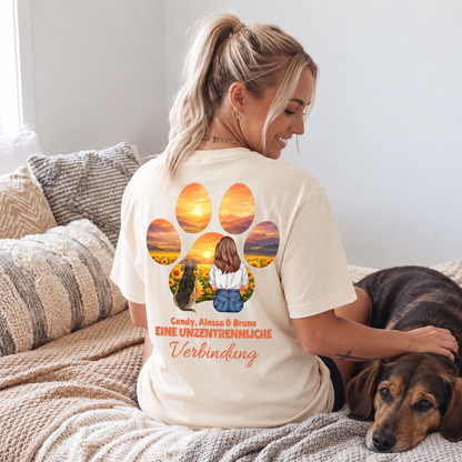 T-shirt beige avec impression graphique d'une fille et d'un chien, entourés d'un coucher de soleil et de fleurs.