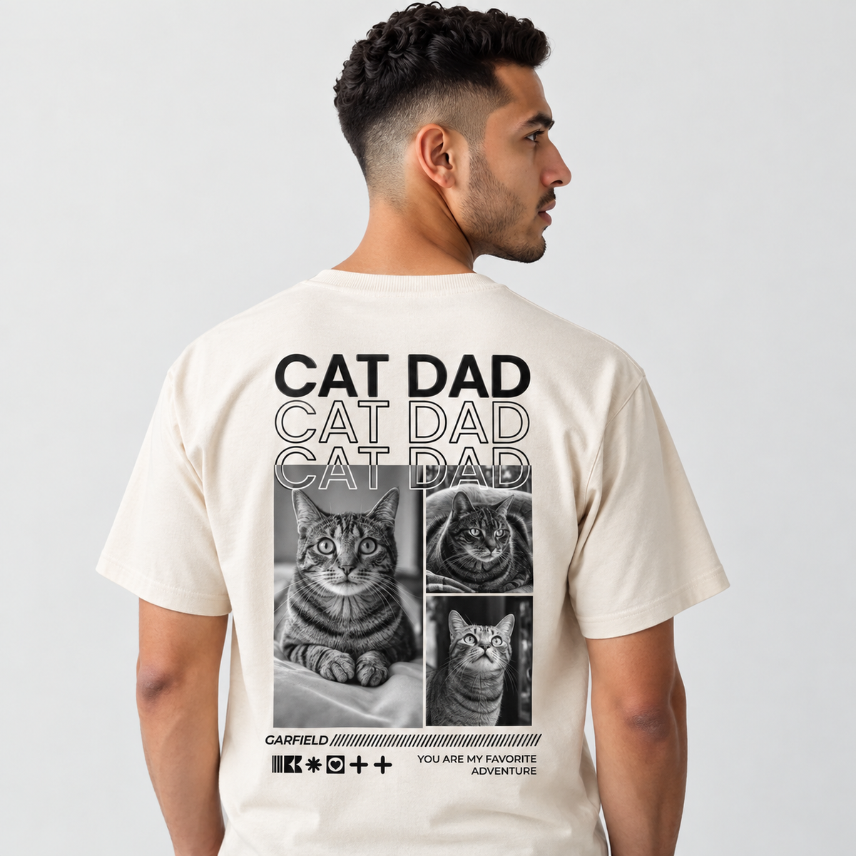 T-shirt beige avec motif de chat et inscription "CAT DAD" au dos.