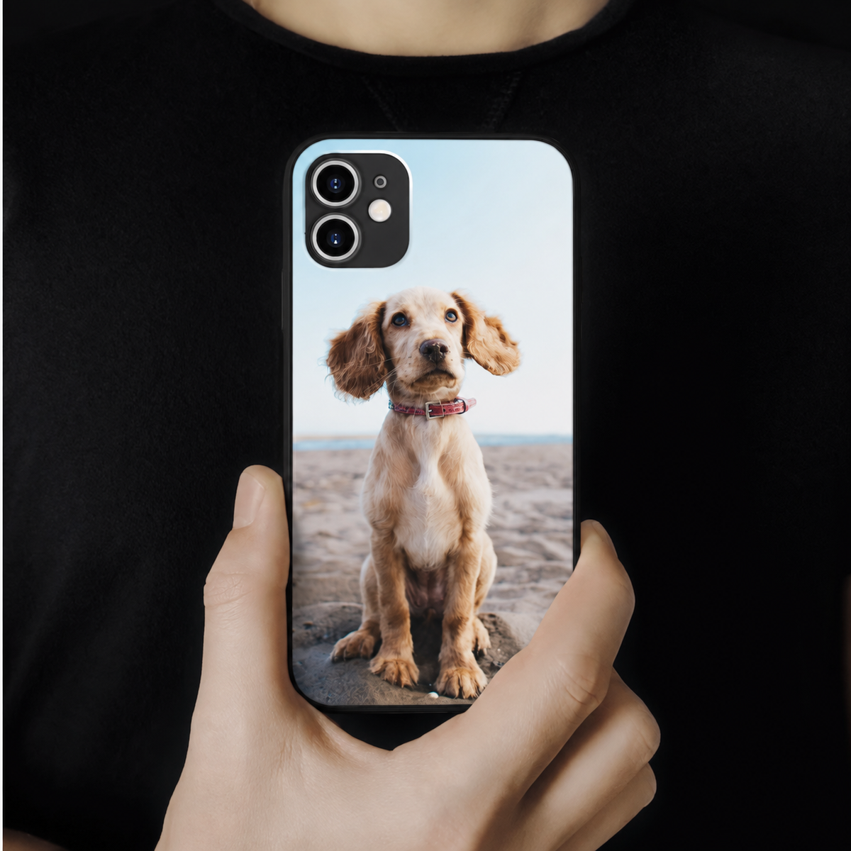 Coque de téléphone personnalisée avec une photo d'un chien, tenue par une personne.