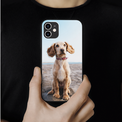 Coque de téléphone personnalisée avec une photo d'un chien, tenue par une personne.