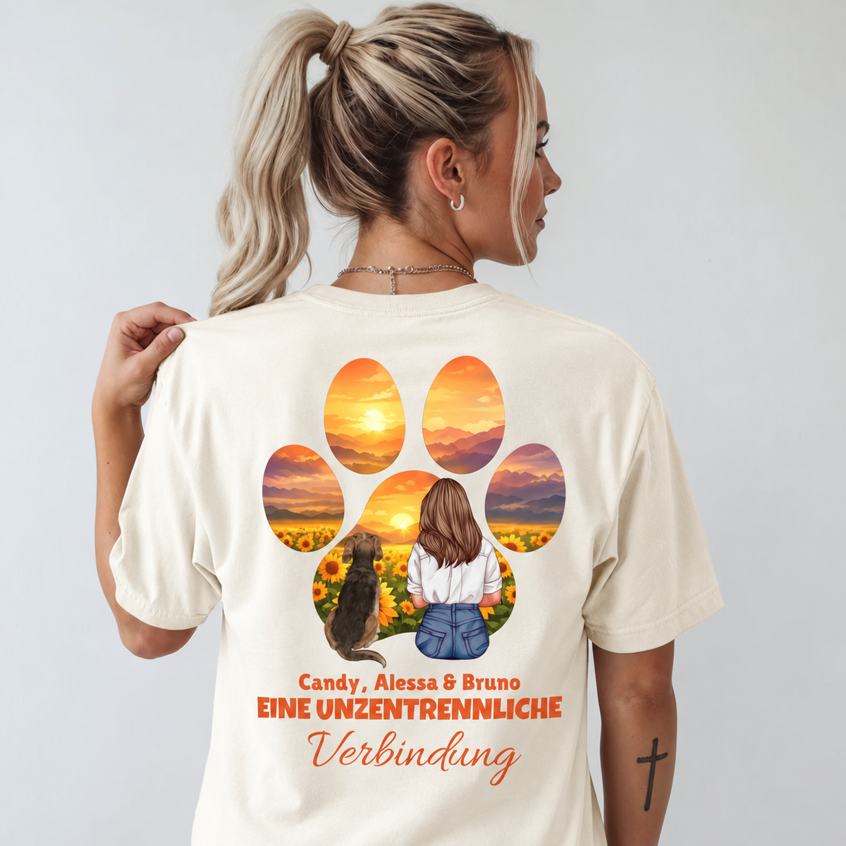 T-shirt beige avec impression couleur d'une femme et d'un chien devant un paysage de tournesols.