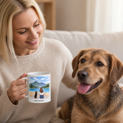 Persoon drinkt uit een gepersonaliseerde witte mok met landschapsontwerp, zittend naast een hond.
