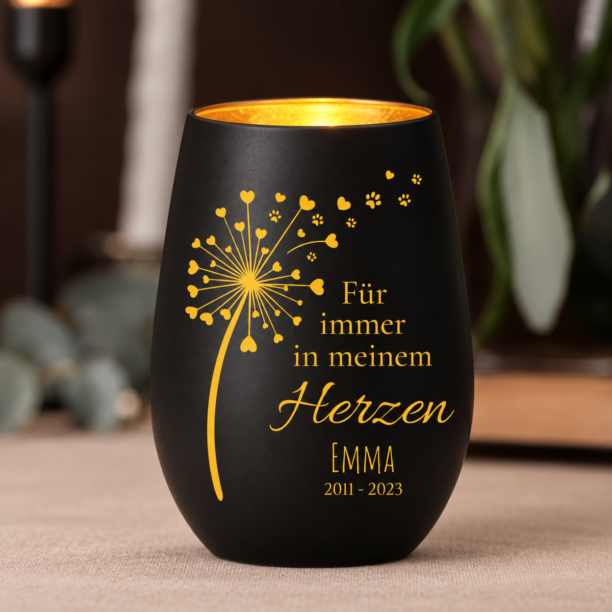 Zwarte herdenkingskaars met gouden opdruk, gepersonaliseerd met naam en jaartallen, als herdenkingslicht.