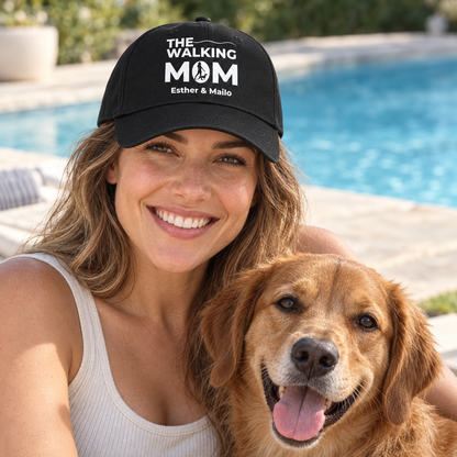Zwarte pet met opdruk “THE WALKING MOM” en gepersonaliseerde namen, gedragen door een vrouw met hond.