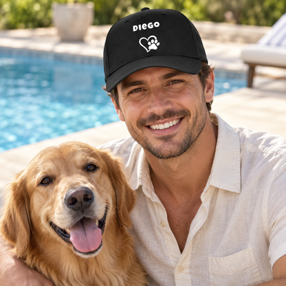 Gepersonaliseerde zwarte pet met de naam “Diego” en pootjesontwerp, gedragen door een man naast een golden retriever.