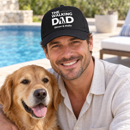 Zwarte pet met opdruk “THE WALKING DAD” en gepersonaliseerde namen, gedragen door een man met hond.
