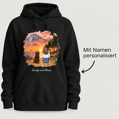 Sweat à capuche noir avec illustration personnalisée d'une personne avec un chien devant un coucher de soleil.