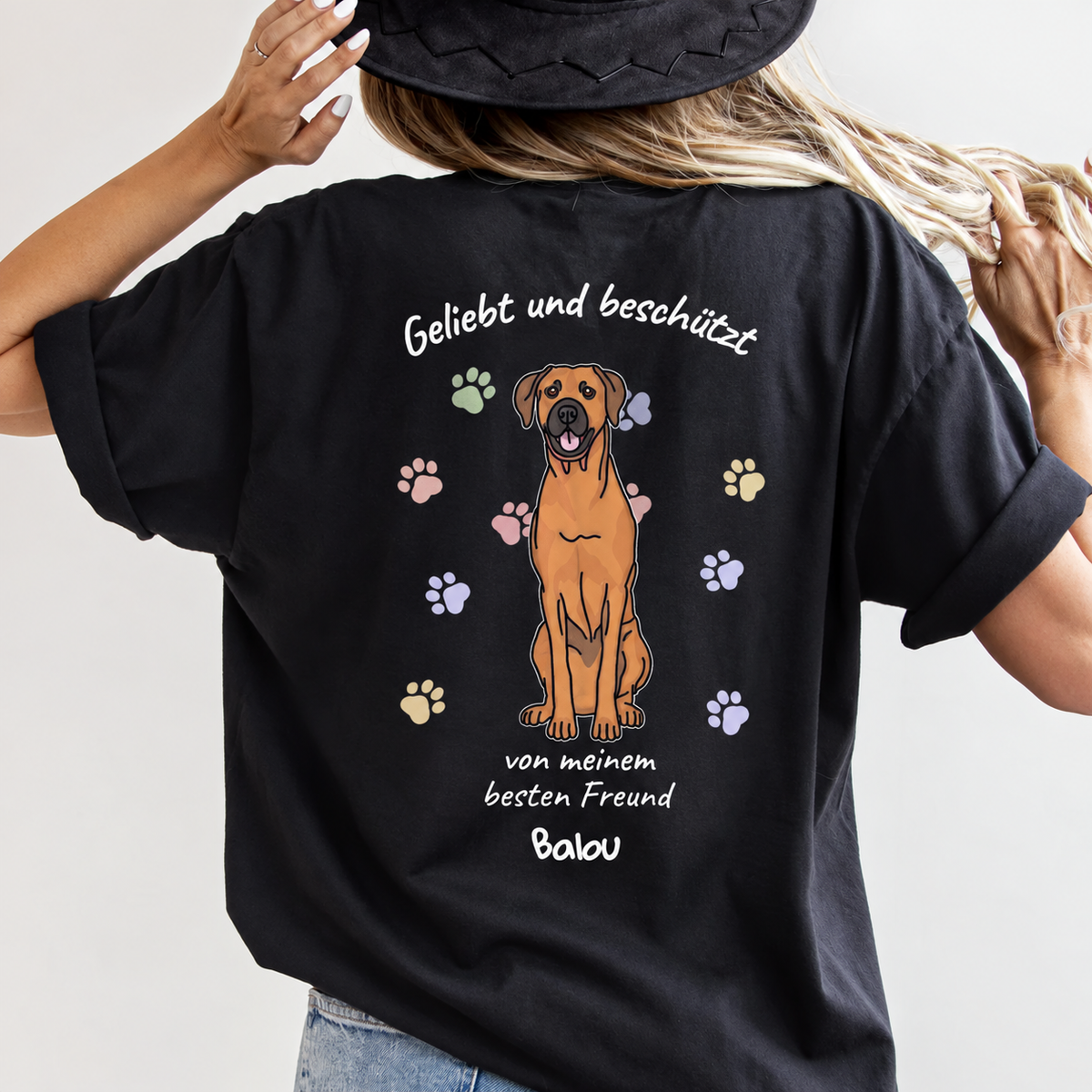 T-shirt noir avec illustration de chien et l'inscription "Geliebt und beschützt" au dos.