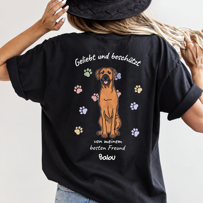 T-shirt noir avec illustration de chien et l'inscription "Geliebt und beschützt" au dos.