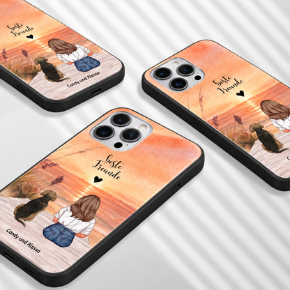 Gepersonaliseerde telefoonhoesjes met illustratie van een vrouw en hond voor een zonsondergang. Kleuren: oranje, bruin.