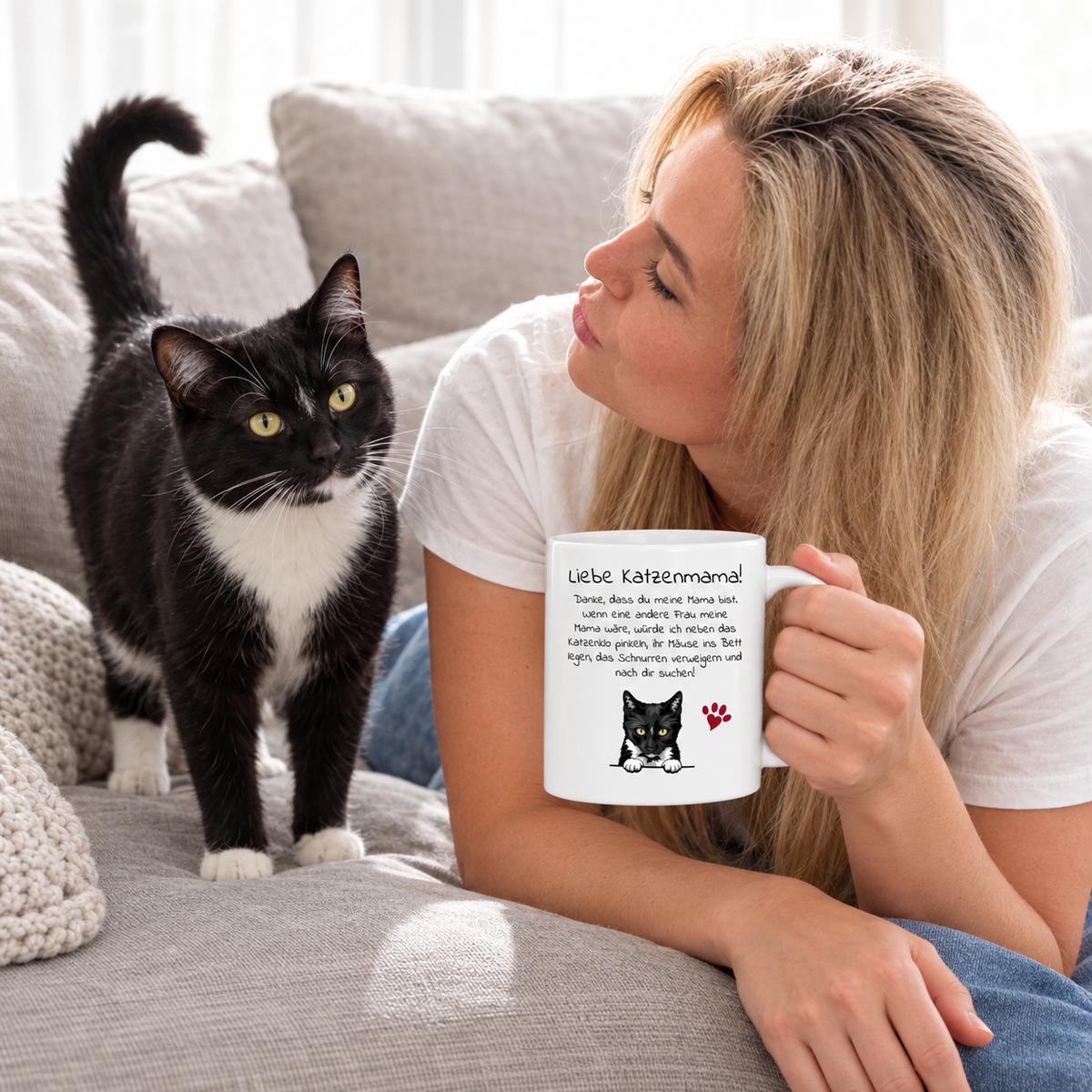 Personne buvant dans un mug blanc à motif de chat, chat noir par terre.