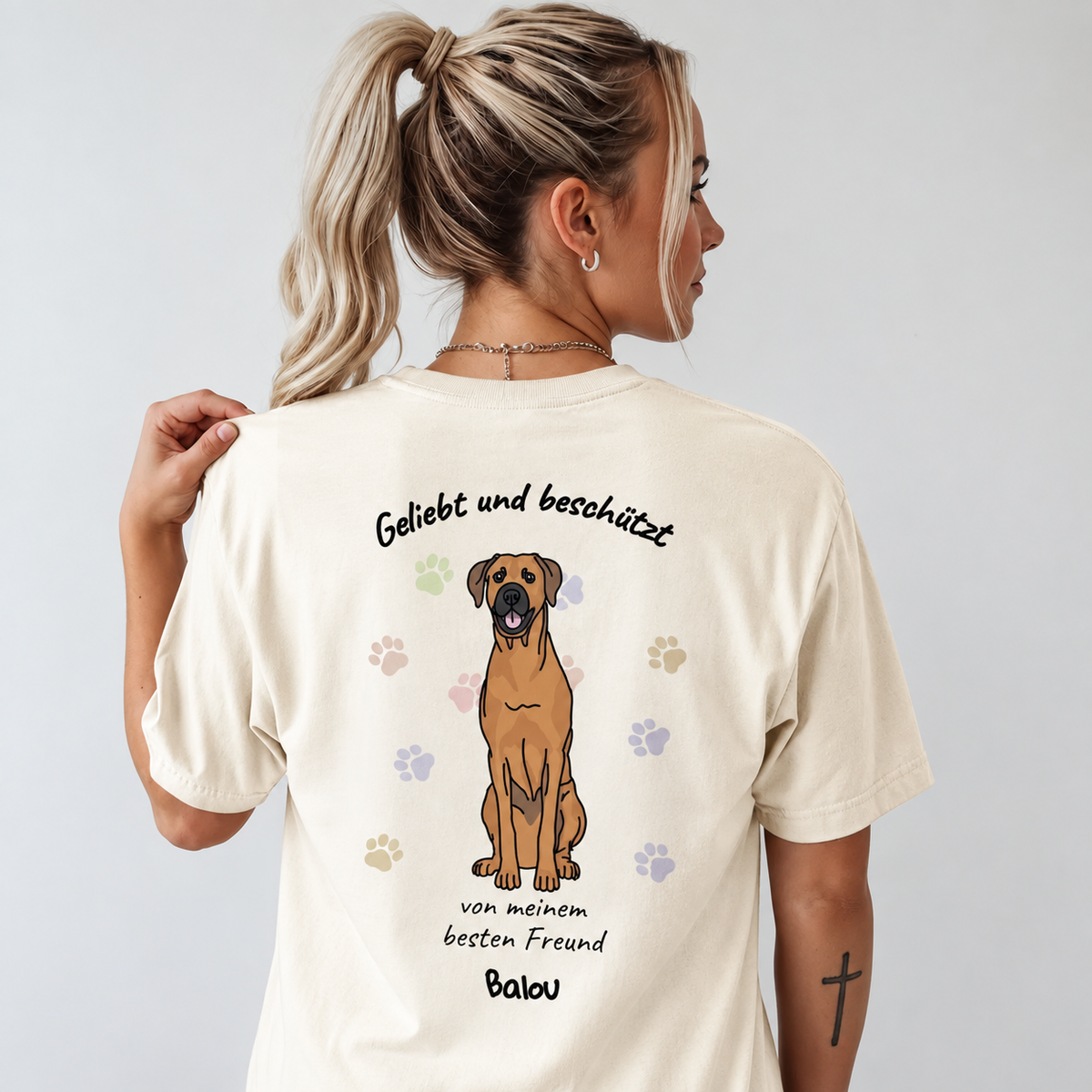T-shirt beige avec motif de chien et le texte "Geliebt und beschützt" au dos.
