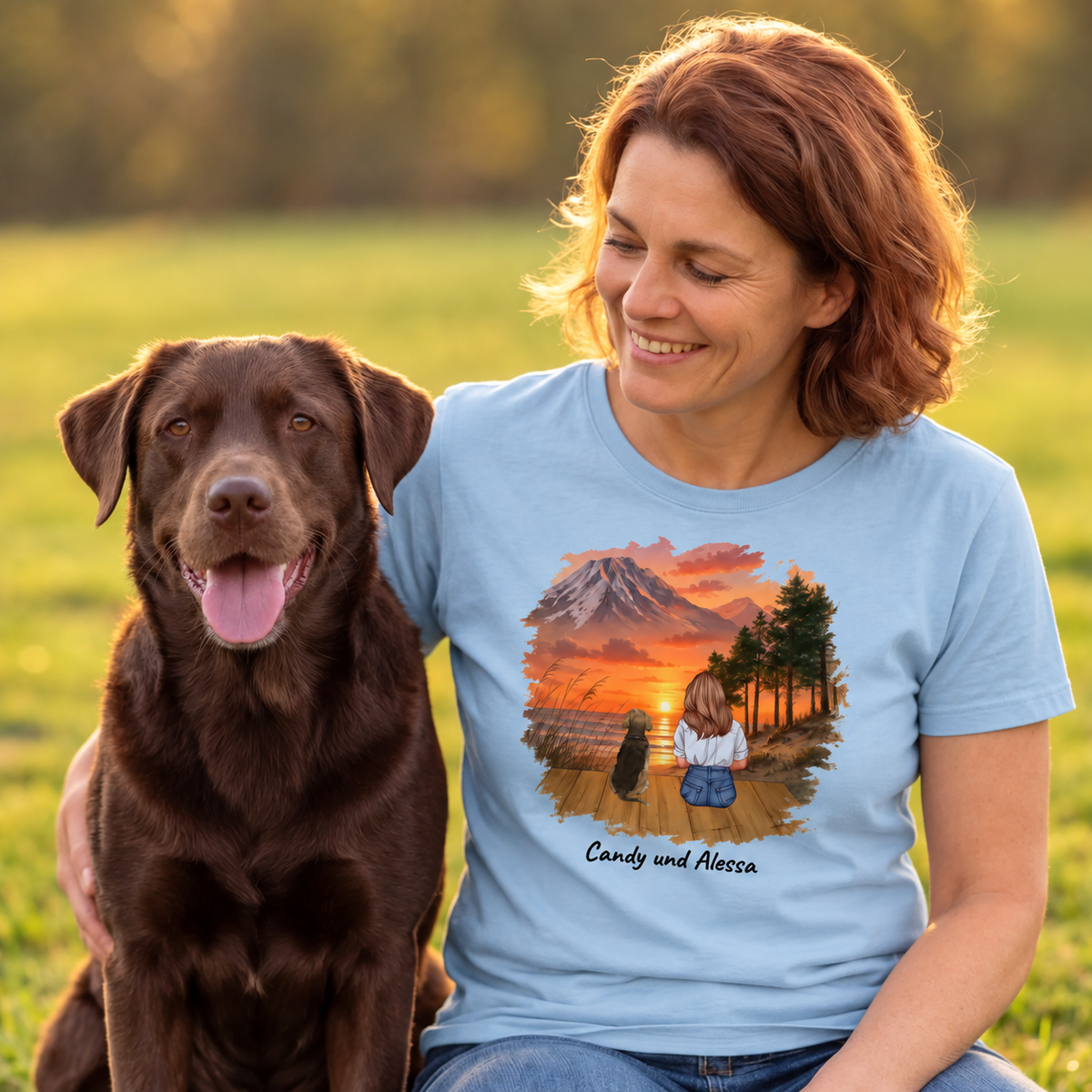 Blauw T-shirt met grafische print van een vrouw en haar hond voor een berglandschap.