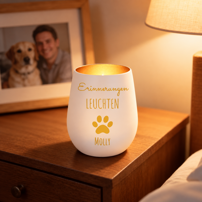 Lumière du souvenir blanche personnalisée avec écriture dorée et motif de patte, posée sur une table en bois.