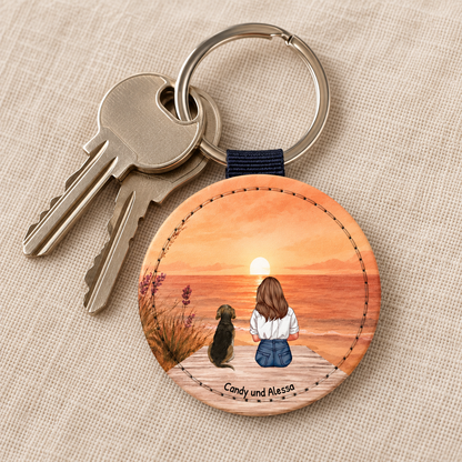 Gepersonaliseerde sleutelhanger met persoon en hond bij zonsondergang. Gegraveerde houten cirkel.