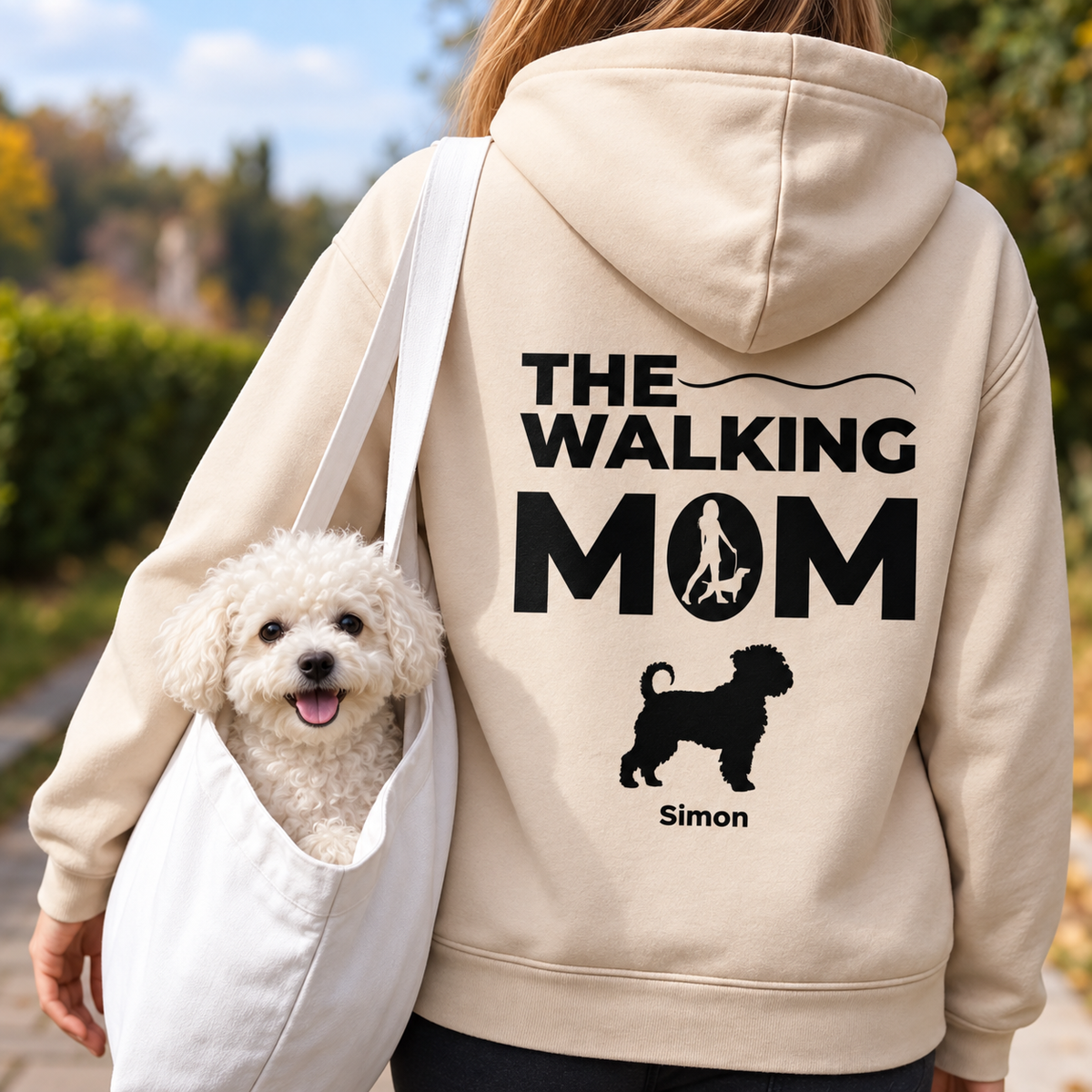Beige hoodie met opdruk "THE WALKING MOM" en hondenmotief, gedragen door iemand met een hond.