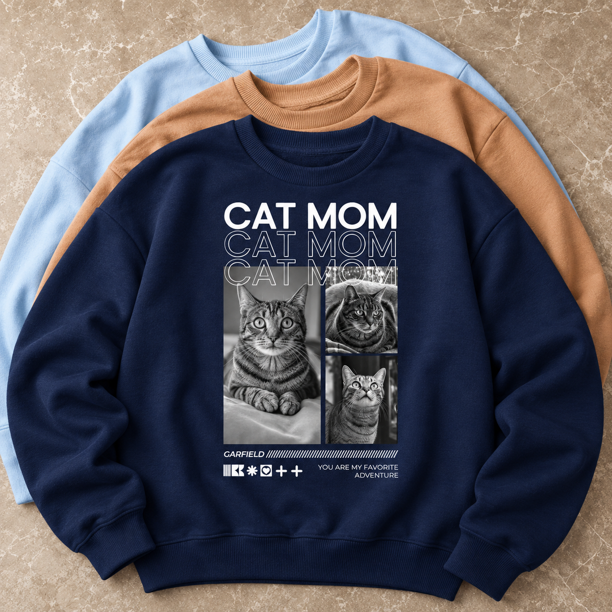 Donkerblauwe sweater met kattenmotieven en de tekst "CAT MOM" in hoofdletters.