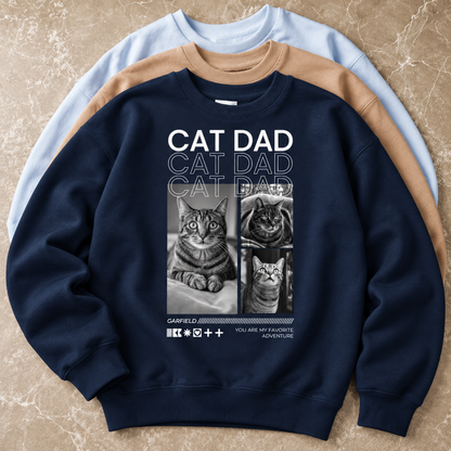 Donkerblauwe sweater met kattenmotieven en de tekst "Cat Dad" op de voorkant.