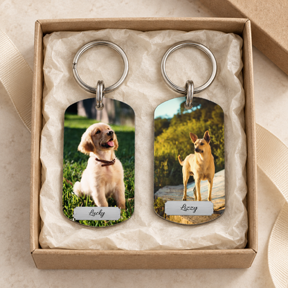 Gepersonaliseerde sleutelhanger met twee foto's van honden in cadeauverpakking.