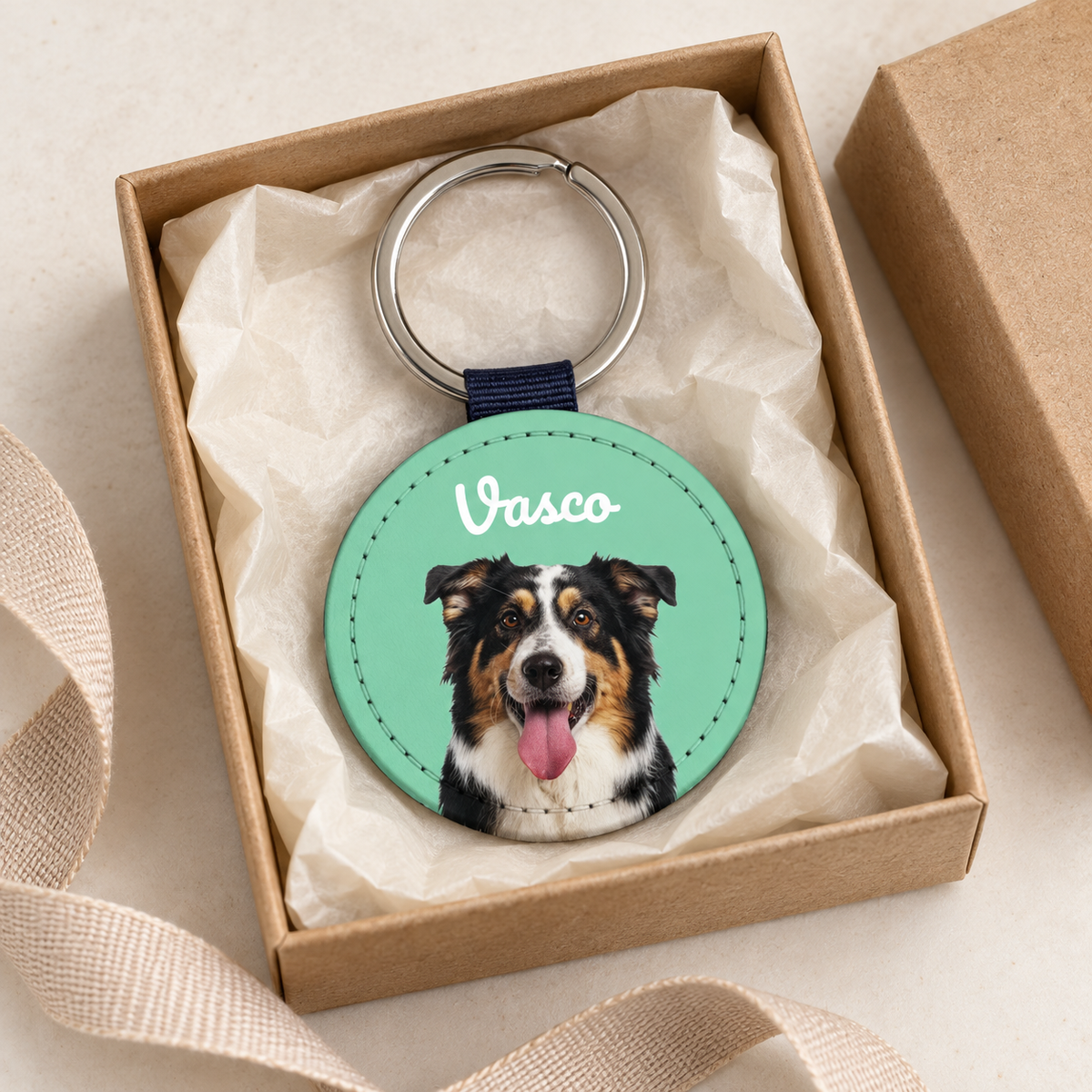 Porte-clés personnalisé avec portrait de chien sur fond vert, emballé dans une boîte cadeau.