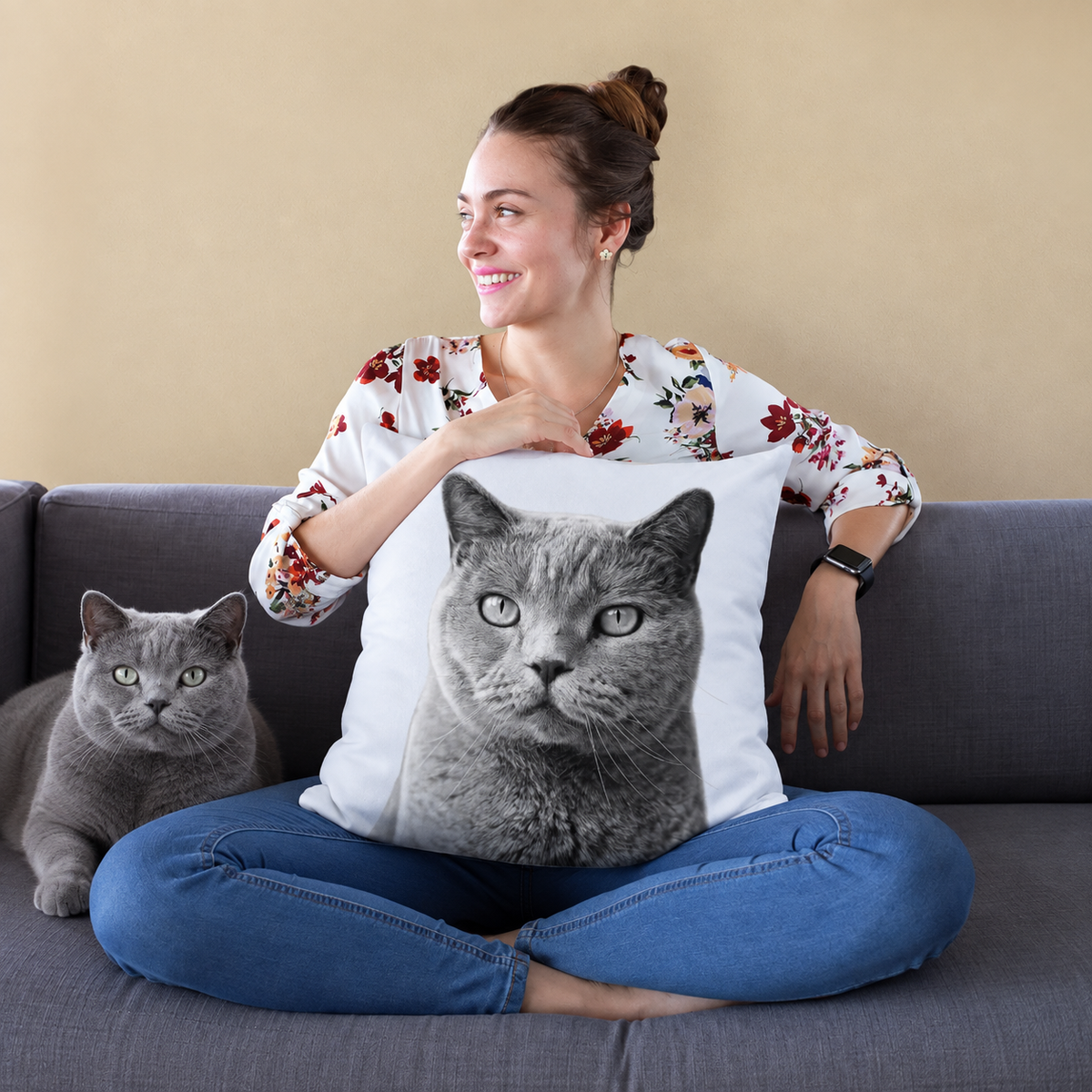 Kussen met zwart-wit kattenportret, persoon zit op een bank en houdt het kussen vast.