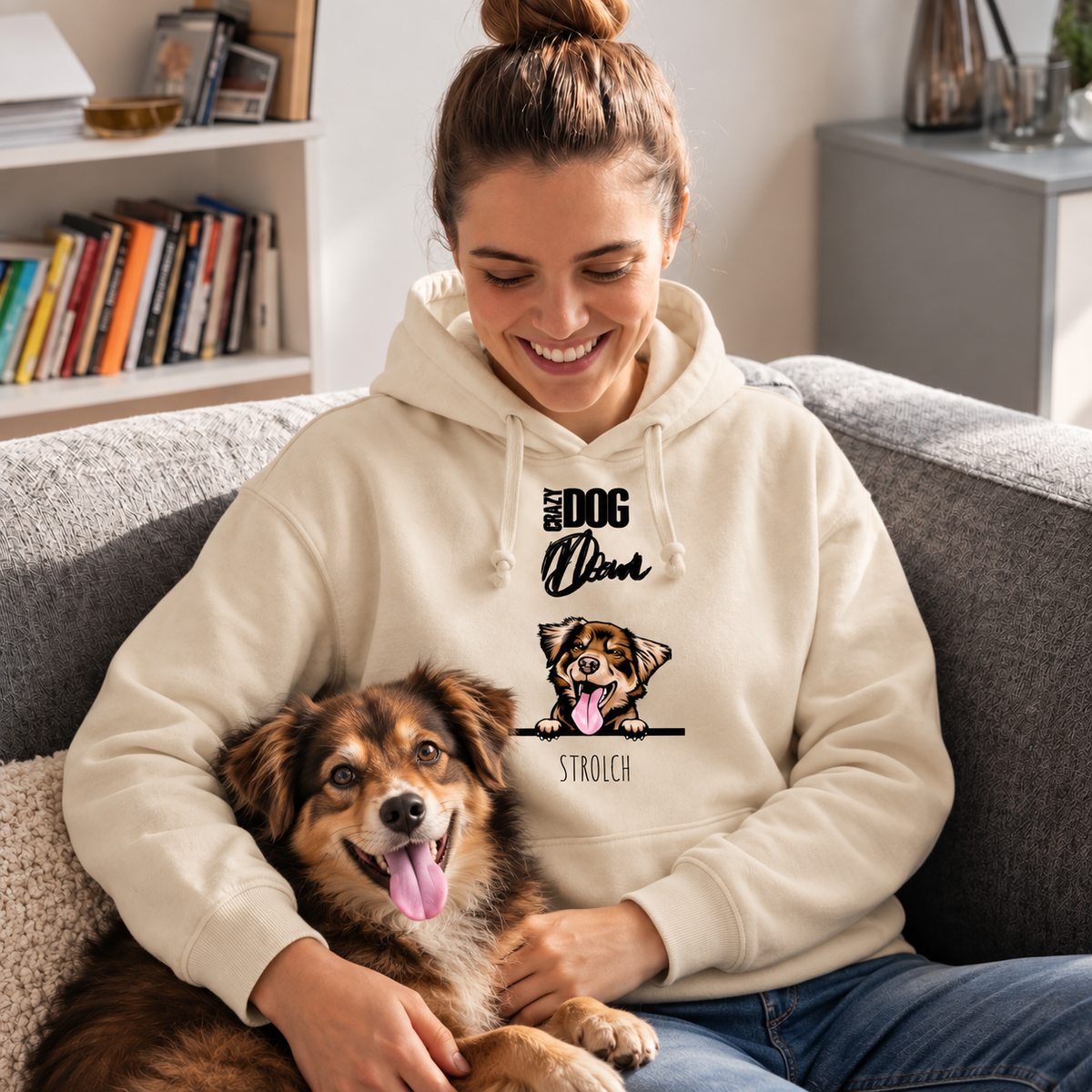 Beige hoodie met borduursel "Crazy Dog Dad" en hond, persoon zit op een bank en houdt zijn hond vast.