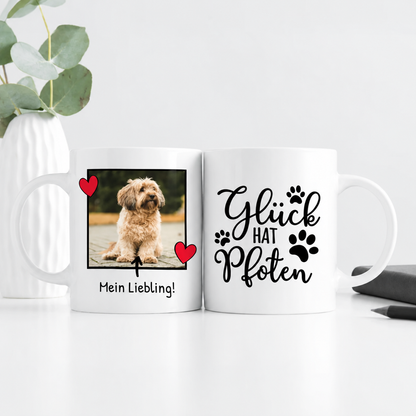 Witte mok met fotoprint van een hond en de tekst "Glück hat Pfoten". Personaliseerbaar, ca. 300 ml.