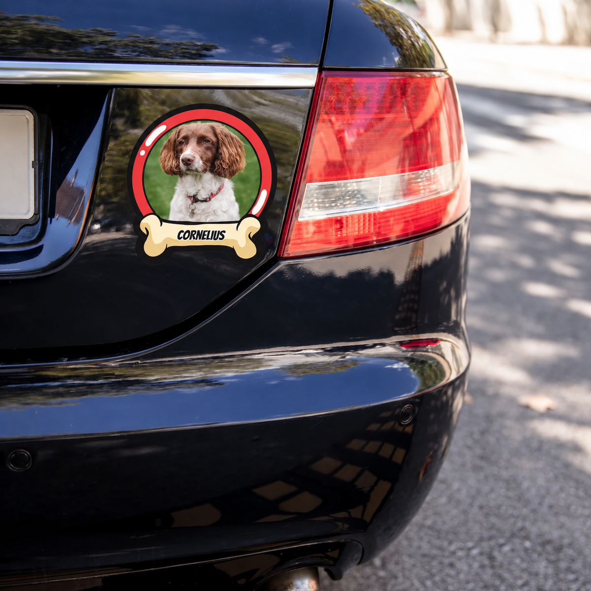 Autocollant de voiture personnalisé avec photo de chien et le nom "CORNELIUS" sur une voiture noire.