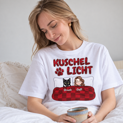 T-shirt blanc avec l'inscription "Kuschel Licht" et illustrations d'une femme et d'un chat au lit.