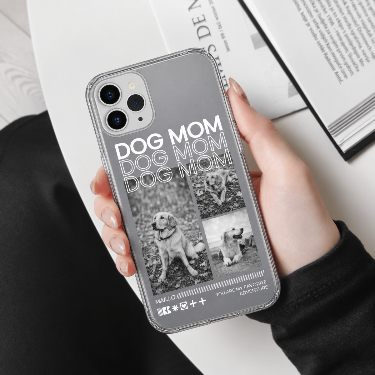 Telefoonhoesje met grijs ontwerp, de tekst "DOG MOM" en afbeeldingen van honden, transparant materiaal.