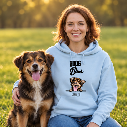 Persoon in lichtblauwe hoodie met hond in het groen, hoodie met opdruk "Crazy Dog Mom".
