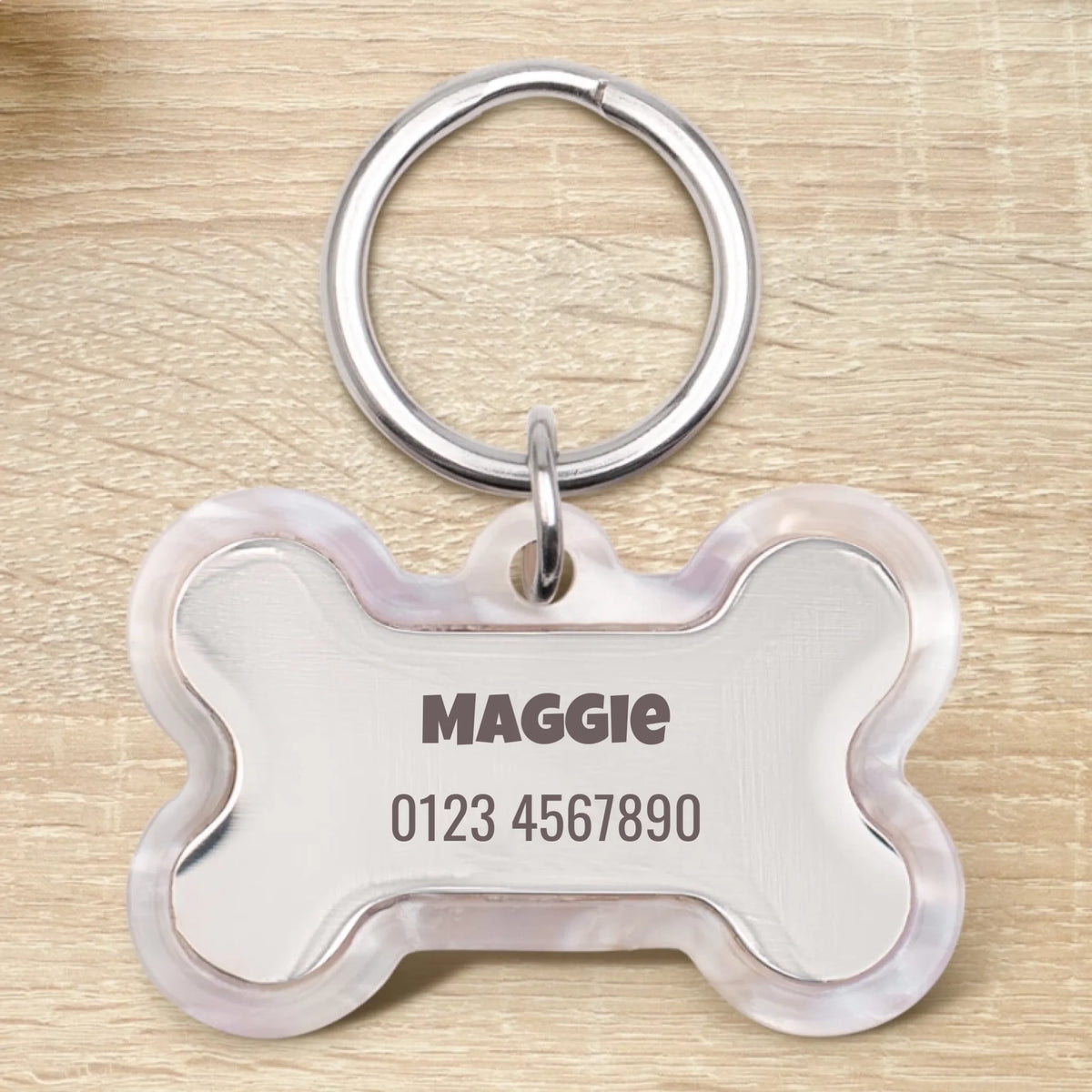 Médaille pour chien en époxy personnalisée en forme d'os avec le nom Maggie et un numéro de téléphone.