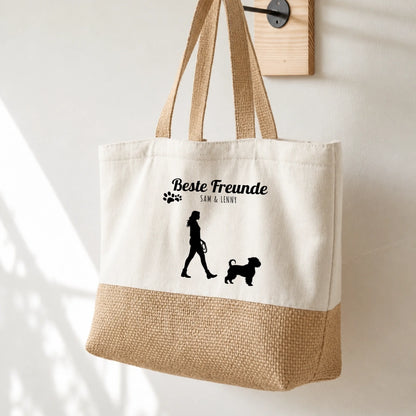 Beige boodschappentas met zwarte opdruk, silhouet van persoon en hond, gepersonaliseerd met namen.