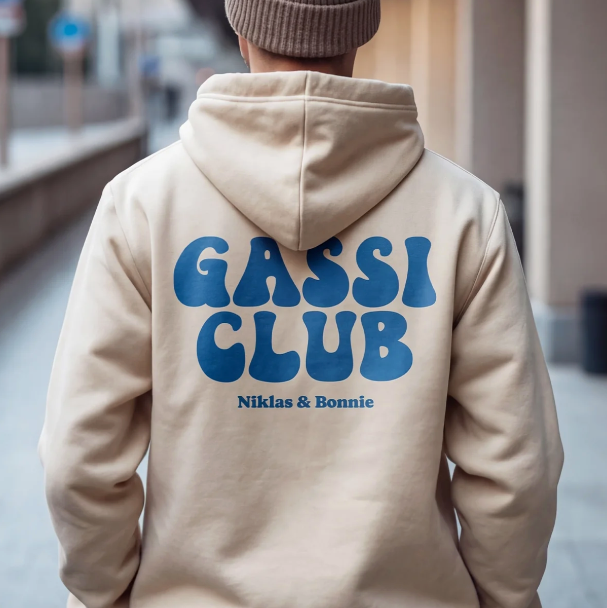 Beige hoodie met blauwe opdruk "GASSI CLUB" en de namen "Niklas & Bonnie" op de rug.