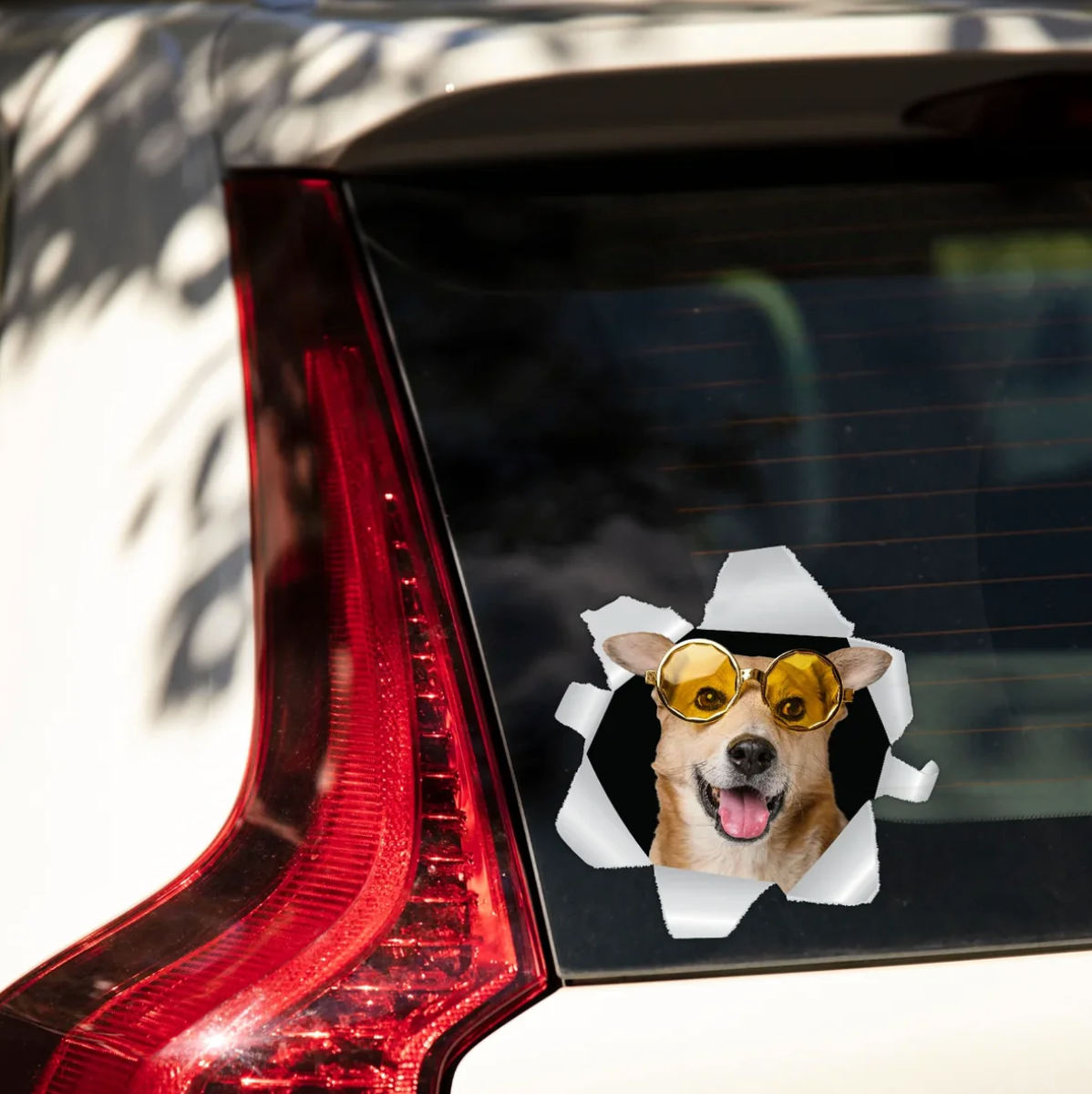 Gepersonaliseerde autosticker met een hond met zonnebril die uit een gescheurd raam kijkt.