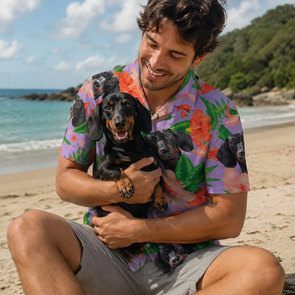 Man houdt een hond vast en draagt een gepersonaliseerd Hawaï-overhemd met kleurrijk patroon op het strand.