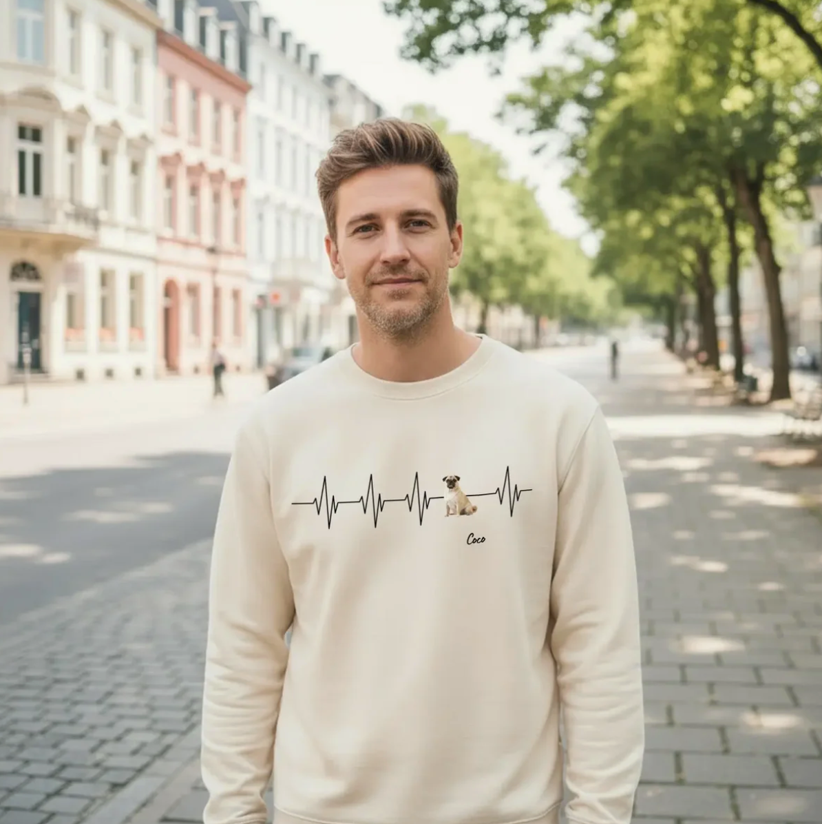 Beige sweater met hartslagmotief en hond, gedragen door een man in een stadsomgeving.