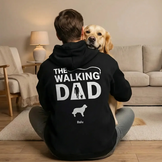 Persoon zit met een hond op schoot in een zwarte hoodie met opdruk "The Walking Dad".