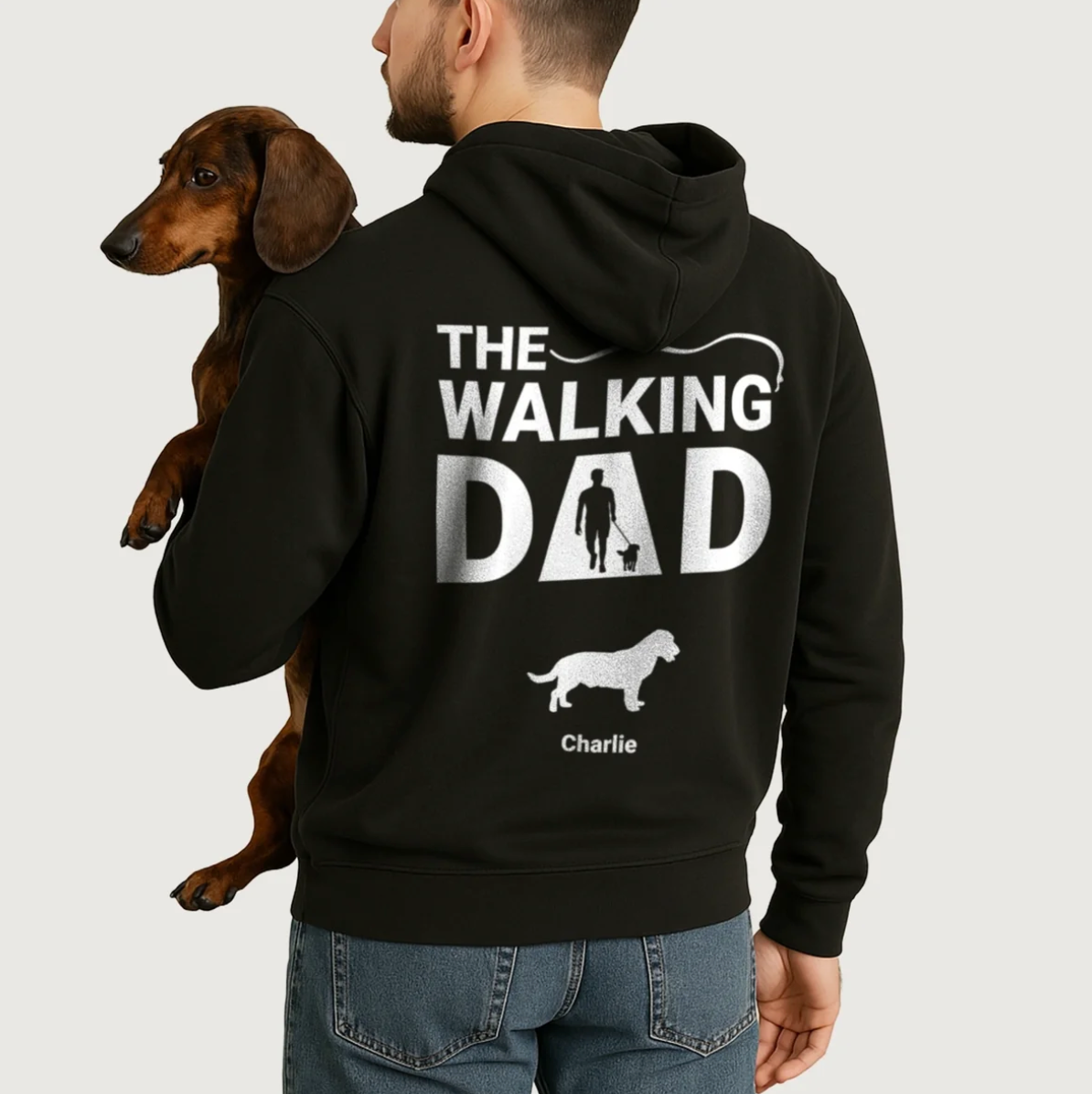 Zwarte hoodie met gepersonaliseerde print "The Walking Dad" en hondenmotieven. Gedragen door een man met een hond.