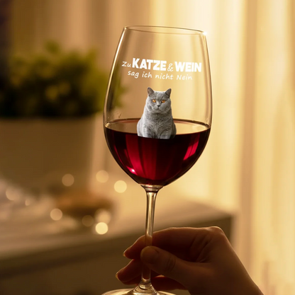 Wijnglas met gravure en een kat op het glas, gevuld met rode wijn.