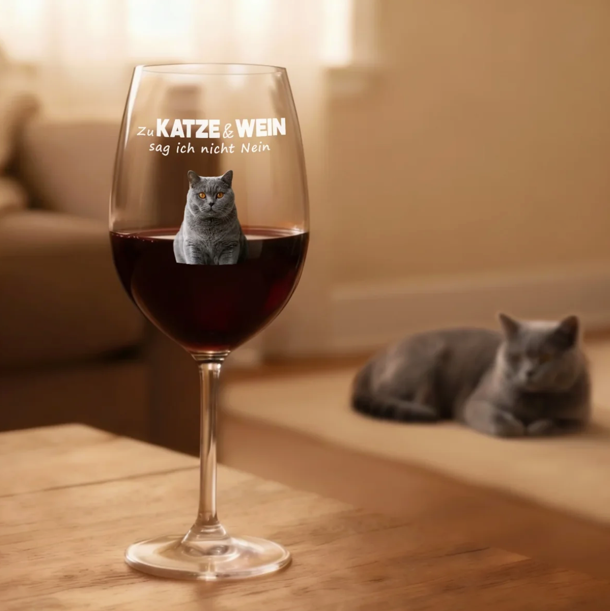 Gepersonaliseerd bedrukt wijnglas met rode wijn, kattenmotief op het glas, houten ondergrond.