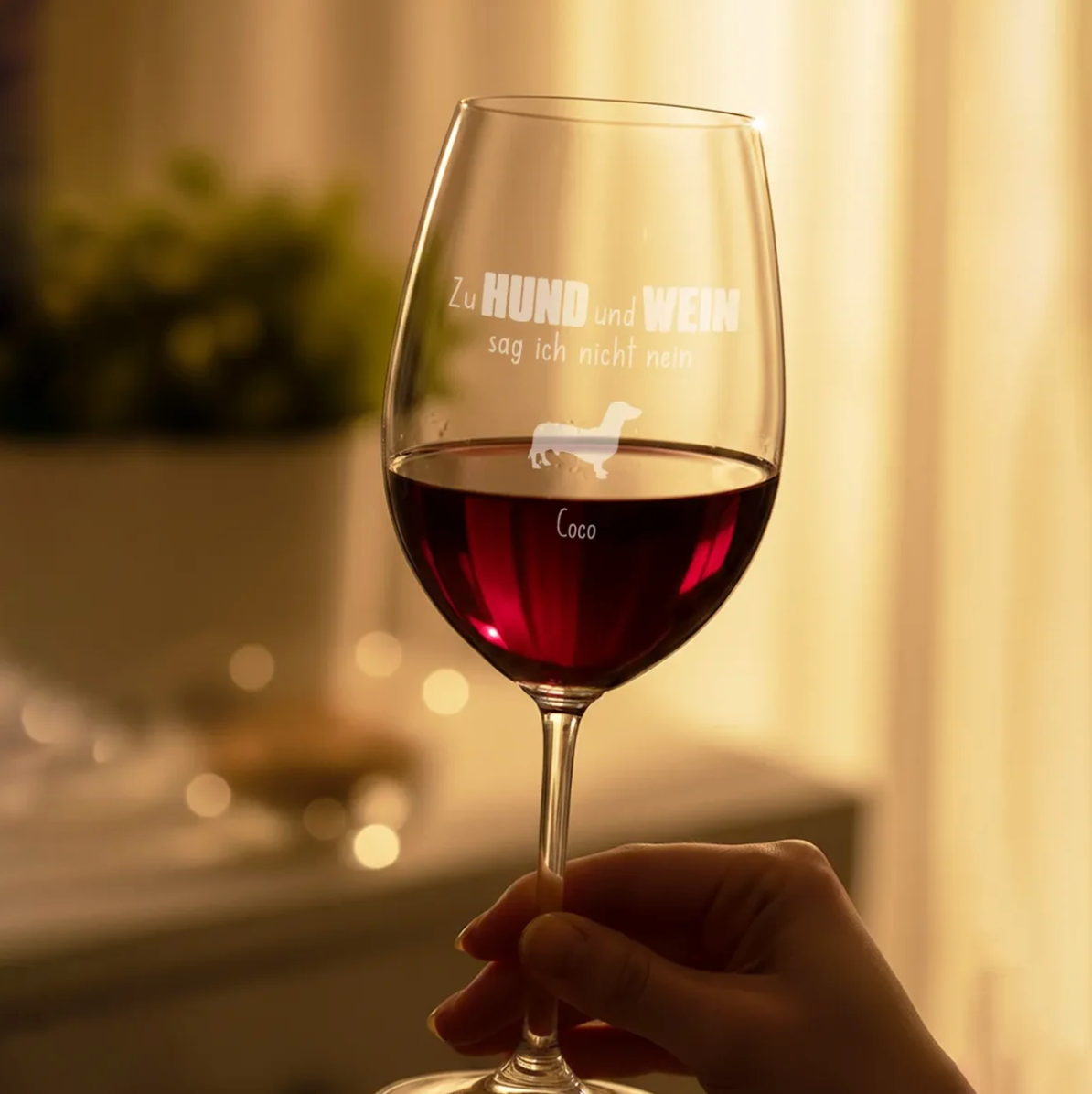 Verre à vin gravé personnalisé avec du vin rouge, décoratif et tenu en main.
