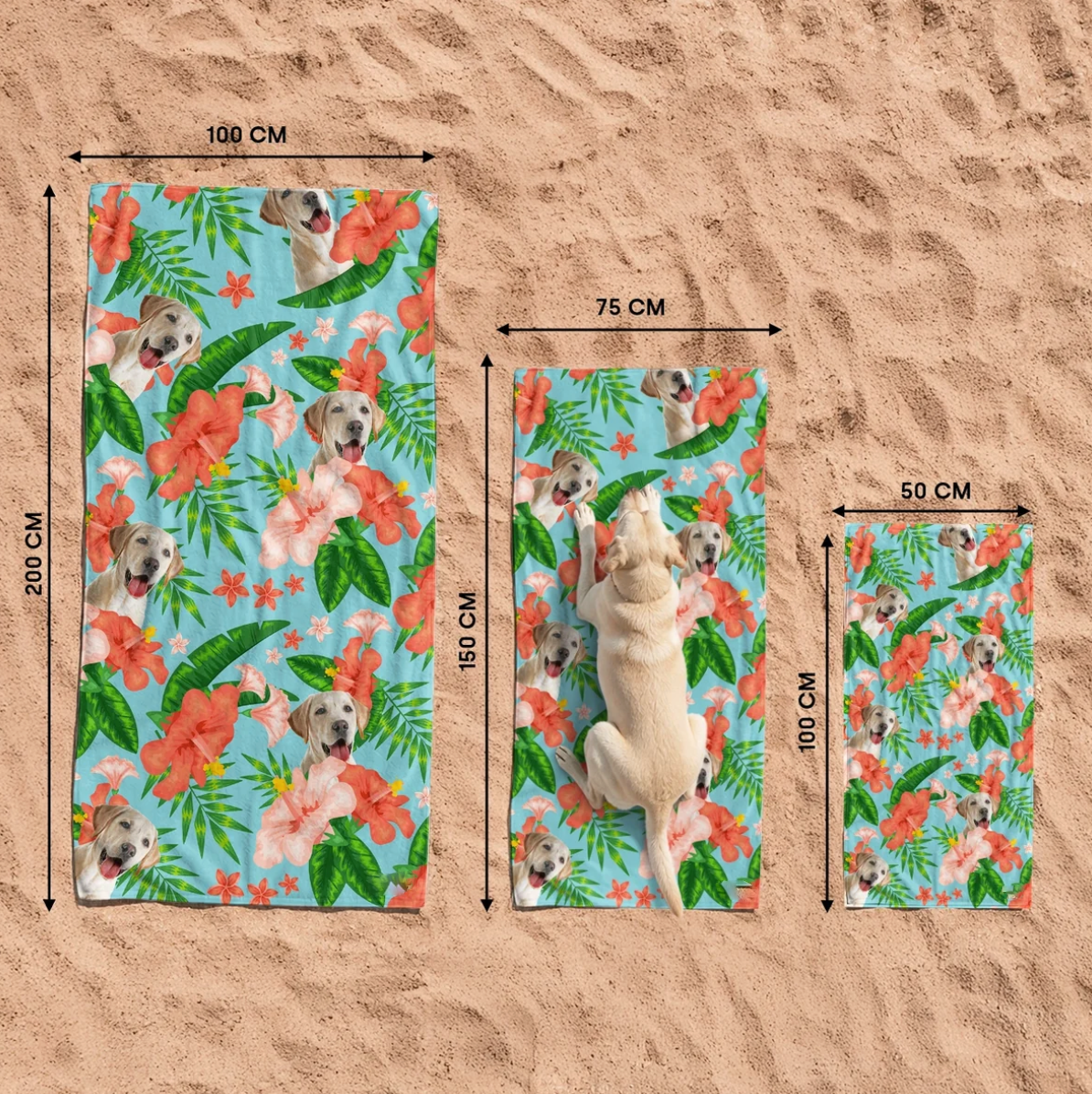 Drie gepersonaliseerde strandhanddoeken met hondenmotief en kleurrijke bloemen op het zand.