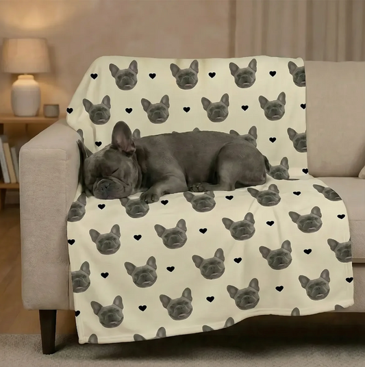 Gepersonaliseerde deken met huisdierkopjes op beige achtergrond, hond ligt er ontspannen op.