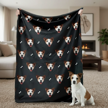 Gepersonaliseerde deken met huisdierkopjes op zwarte achtergrond, vastgehouden door iemand met een hond op de voorgrond.