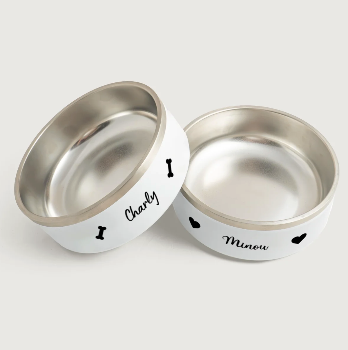 Gamelles personnalisées en inox à l'extérieur blanc, imprimées avec les prénoms Charly et Minou.