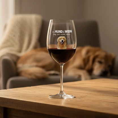 Verre à vin personnalisé avec motif de chien et inscription, rempli de vin rouge sur une table en bois.