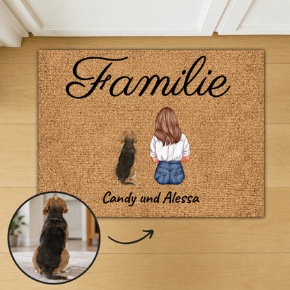 Gepersonaliseerde kokosvezelmat met het woord "Familie" en illustraties van een vrouw en een hond.